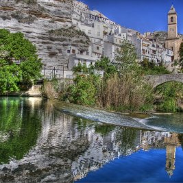 Vista panorámica de Alcalá del Júcar colgado en la ladera de la hoz sobre el meandro del río Júcar