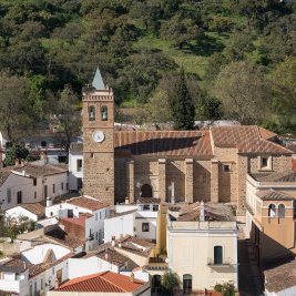 Vista de Almonaster la Real con su mezquita del siglo X en lo alto del cerro y el caserío blanco rodeado de castañares