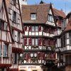 Casas de entramado de madera y colores junto a un canal florido en Colmar, Alsacia