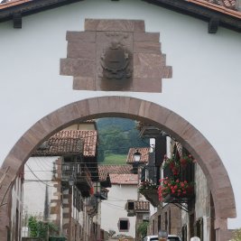 Calle principal de Amaiur con sus caseríos blasonados del valle de Baztan y colinas verdes al fondo