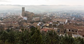 Murallas y torreones del Cerco de Artajona coronando el cerro entre campos de cereal