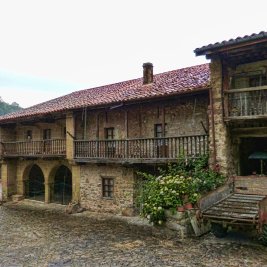 Panorámica de las casas de piedra y balcones de madera de Bárcena Mayor entre los bosques del valle de Cabuérniga