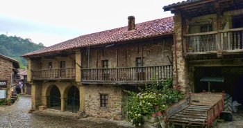 Panorámica de las casas de piedra y balcones de madera de Bárcena Mayor entre los bosques del valle de Cabuérniga