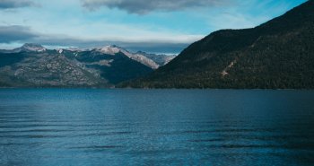 Vista del lago Nahuel Huapi con bosques y montañas nevadas cerca de Bariloche