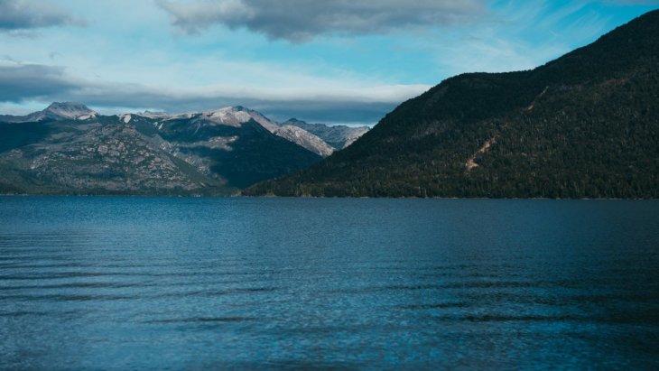 Vista del lago Nahuel Huapi con bosques y montañas nevadas cerca de Bariloche