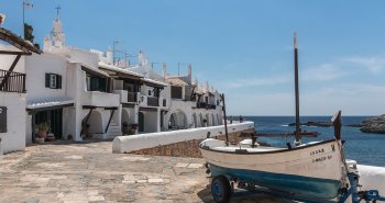 Callejuelas blancas y casas encaladas de Binibeca Vell, el pueblo de pescadores de Menorca, junto al mar Mediterráneo