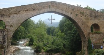 Puente romano de Cangas de Onís sobre el río Sella, con la Cruz de la Victoria colgando de su arco central