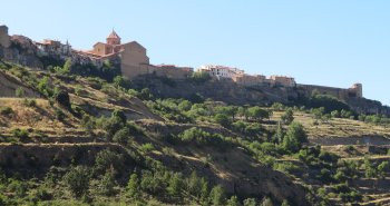 Cantavieja encaramada a su espolón rocoso sobre el barranco, con las montañas del Maestrazgo al fondo