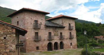 Casonas montañesas de piedra con balconadas de madera en el pueblo de Carmona, en el valle de Cabuérniga