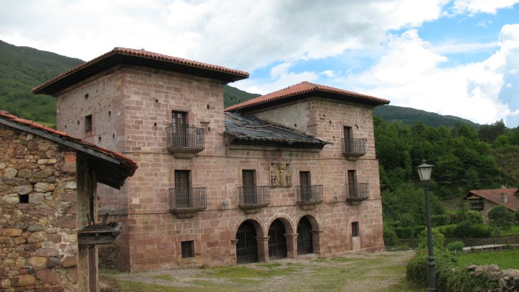 Casonas montañesas de piedra con balconadas de madera en el pueblo de Carmona, en el valle de Cabuérniga