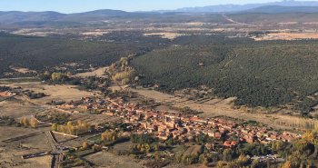 Calle empedrada de Castrillo de los Polvazares con casas de piedra rojiza y portones arrieros
