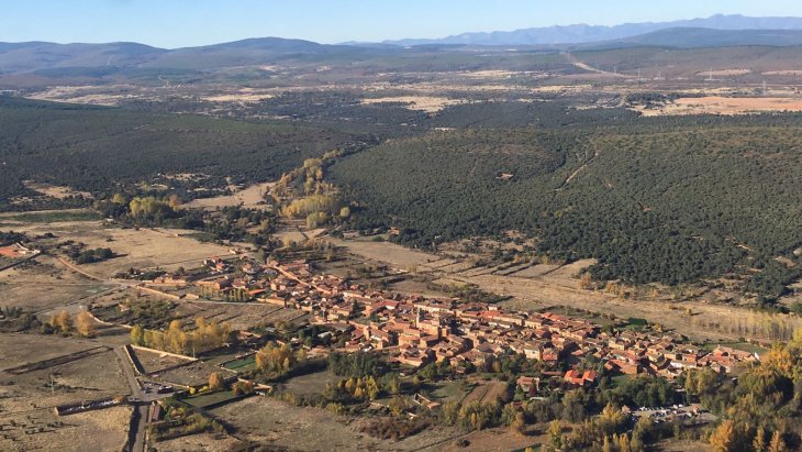 Calle empedrada de Castrillo de los Polvazares con casas de piedra rojiza y portones arrieros