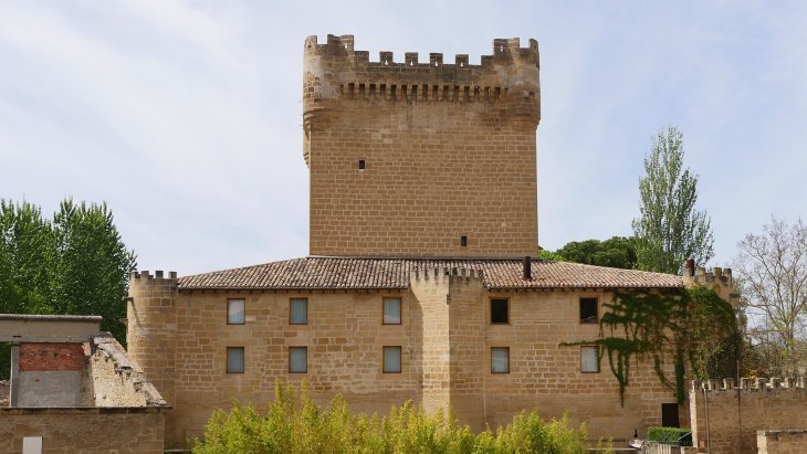 Vista del castillo medieval de Cuzcurrita de Río Tirón junto al puente de piedra sobre el río