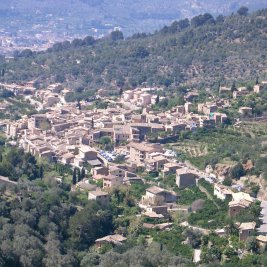 Vista panorámica de Fornalutx, pueblo de piedra con tejados árabes rodeado de bancales de naranjos y las montañas de la Serra de Tramuntana