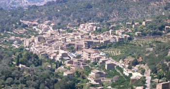 Vista panorámica de Fornalutx, pueblo de piedra con tejados árabes rodeado de bancales de naranjos y las montañas de la Serra de Tramuntana