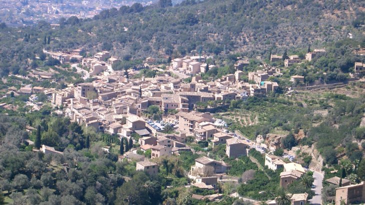 Vista panorámica de Fornalutx, pueblo de piedra con tejados árabes rodeado de bancales de naranjos y las montañas de la Serra de Tramuntana