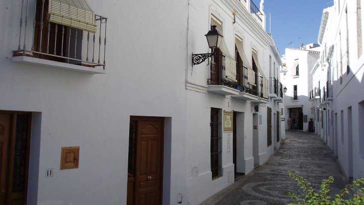 Vista panorámica de las casas blancas de Frigiliana en la ladera de la sierra, con el Mediterráneo al fondo