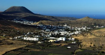 Vista panorámica del valle de las mil palmeras de Haría, con casas blancas entre palmerales y montañas volcánicas, en Lanzarote