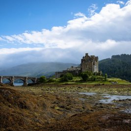 Castillo de Eilean Donan reflejado en el lago al atardecer, Highlands de Escocia