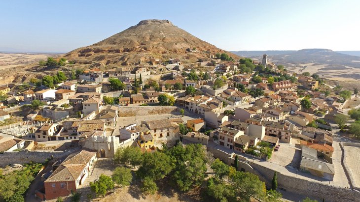 Vista de Hita (Guadalajara) al pie de su cerro, con la Puerta de Santa María y el caserío de la villa medieval