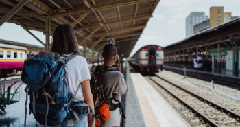 Jóvenes con mochilas esperando un tren en una estación europea