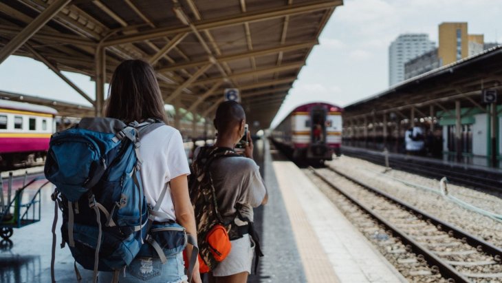 Jóvenes con mochilas esperando un tren en una estación europea