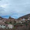 Vista panorámica de Isaba con sus tejados de piedra bajo la iglesia-fortaleza de San Cipriano y las montañas del Pirineo
