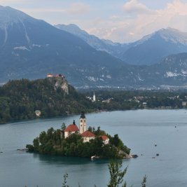 Isla con iglesia en el lago Bled rodeada de montañas de los Alpes Julianos