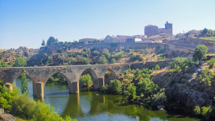 Vista de Ledesma amurallada sobre el río Tormes con el puente viejo en primer término