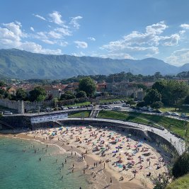 Panorámica de la villa de Llanes con su puerto, los Cubos de la Memoria y la sierra del Cuera al fondo