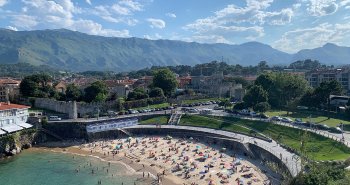 Panorámica de la villa de Llanes con su puerto, los Cubos de la Memoria y la sierra del Cuera al fondo