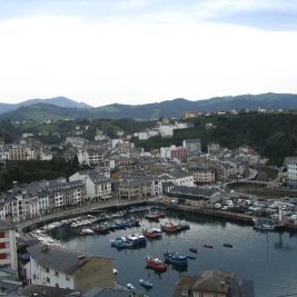 Vista panorámica de las casas blancas de Luarca alrededor de su puerto pesquero al atardecer