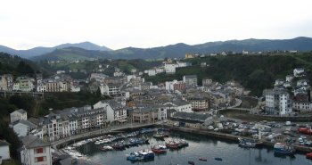 Vista panorámica de las casas blancas de Luarca alrededor de su puerto pesquero al atardecer