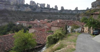 La cascada de Orbaneja del Castillo cayendo entre las casas de piedra hacia el cañón del Ebro
