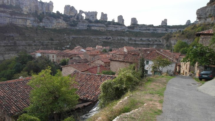La cascada de Orbaneja del Castillo cayendo entre las casas de piedra hacia el cañón del Ebro