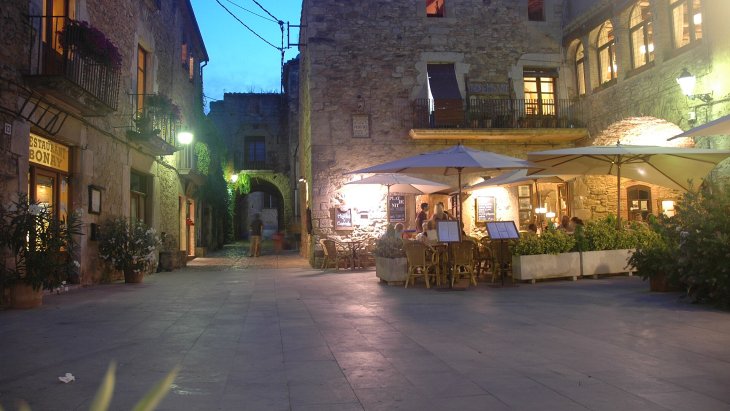 Calle empedrada de Peratallada flanqueada por casas medievales de piedra tallada