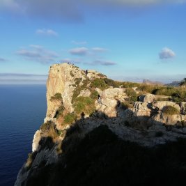 Panorámica de Pollença con sus tejados de teja árabe, la escalinata del Calvari entre cipreses y las montañas de la Tramuntana detrás
