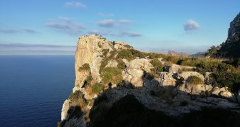 Panorámica de Pollença con sus tejados de teja árabe, la escalinata del Calvari entre cipreses y las montañas de la Tramuntana detrás