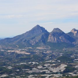 Vista panorámica de Polop de la Marina sobre su colina, con la sierra del Ponoig al fondo