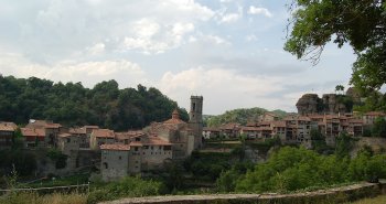 Casas de piedra de Rupit junto a la riera con el puente colgante en primer plano