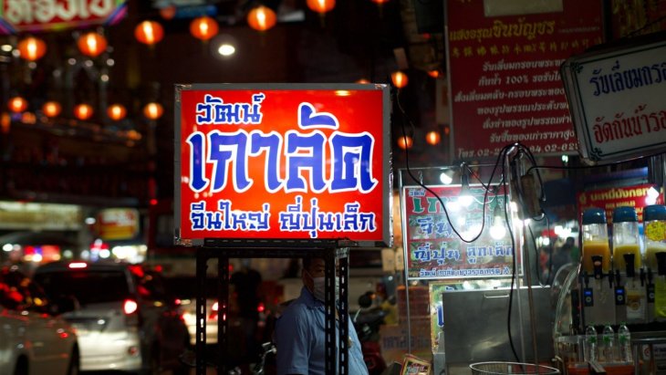 Puesto de comida callejera humeante en una calle de Bangkok
