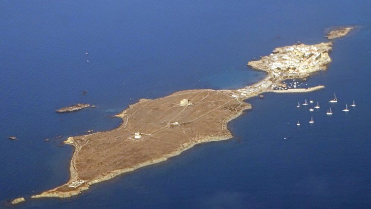 Vista de la isla de Tabarca con sus casas junto al mar, la iglesia de San Pedro y San Pablo y aguas turquesas