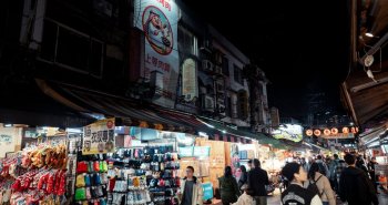 Mercado nocturno de Taipéi lleno de puestos de comida y letreros luminosos