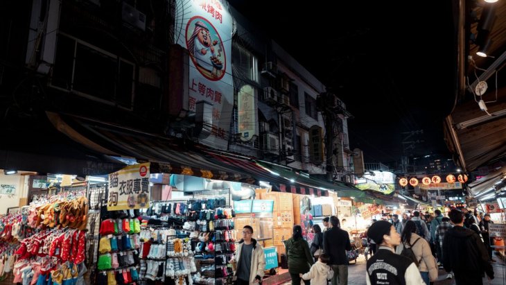 Mercado nocturno de Taipéi lleno de puestos de comida y letreros luminosos
