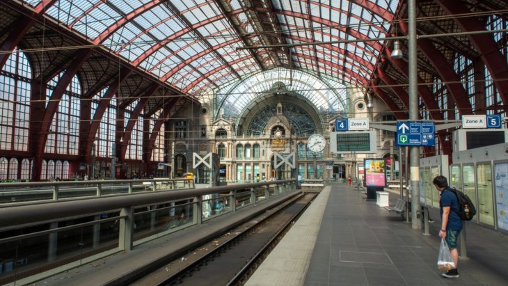 Interior monumental de una estación de tren histórica con gran cúpula y escalinatas