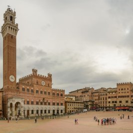 Gran plaza histórica europea rodeada de fachadas antiguas y llena de ambiente