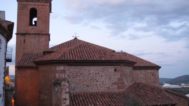 Vista panorámica de Vilafamés con sus casas de piedra rodena roja y el castillo con su torre circular en lo alto