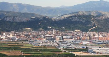 Vista panorámica de Xàtiva con su castillo doble recorriendo la cresta de la sierra sobre los tejados de la ciudad