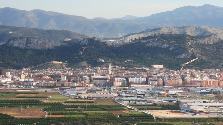 Vista panorámica de Xàtiva con su castillo doble recorriendo la cresta de la sierra sobre los tejados de la ciudad