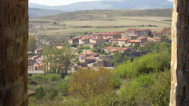 Vista del caserío de piedra rojiza de Yanguas con la torre románica de San Miguel destacando sobre los tejados